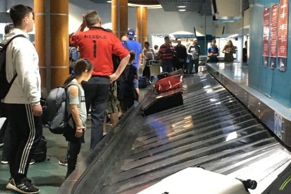 People standing at airport baggage carousel