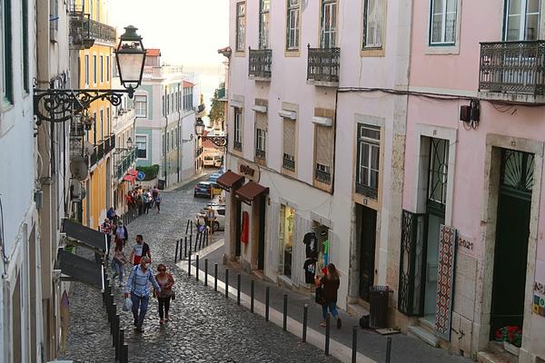 Pedestrians walking hill in Alfama District Lisbon Portugal
